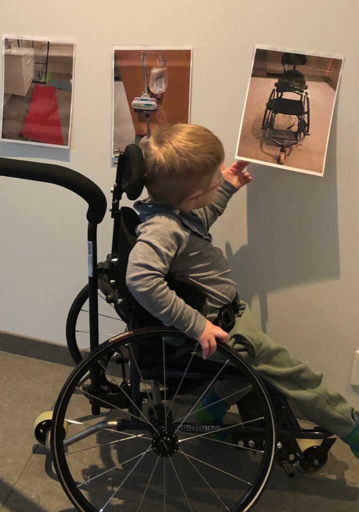 Barn i rullestol ser på bilder på tianhjemmet